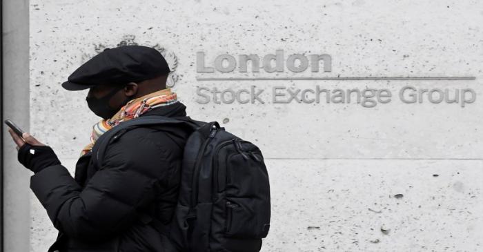 A man wearing a protective face mask walks past the London Stock Exchange Group building in the