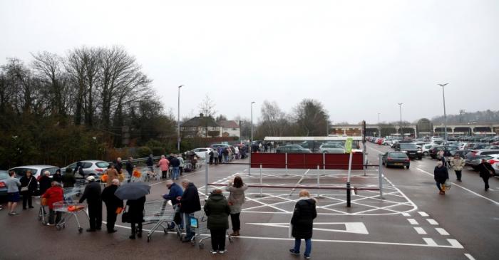 People queue outside of a Sainsbury's supermarket in St Albans