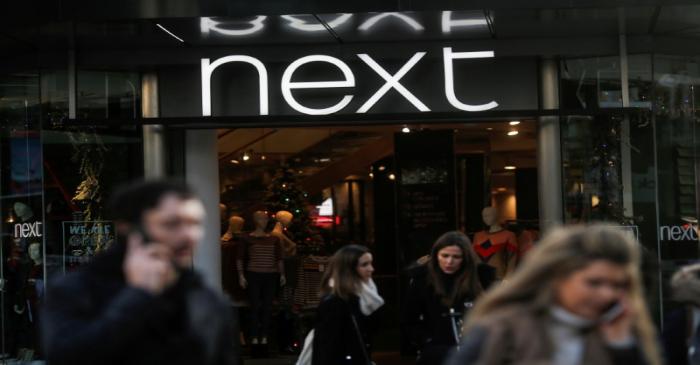 FILE PHOTO: Shoppers walk past a Next store on Oxford Street in London