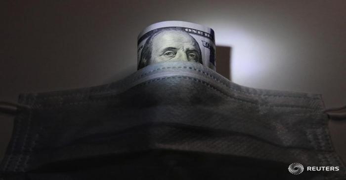 A U.S. dollar banknote is pictured behind a protective mask in this illustration