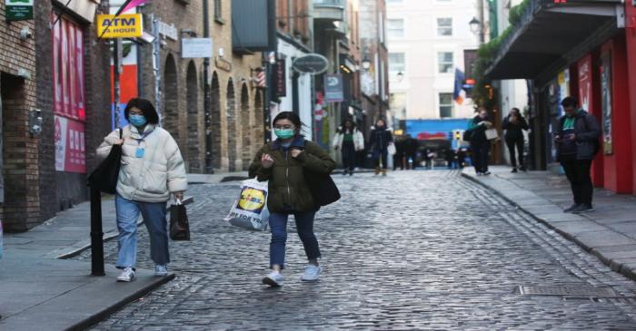 FILE PHOTO:  Tourists with face masks walk around Temple Bar area, as bars across Ireland close