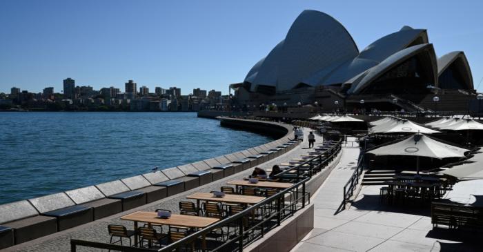 Tables at an open restaurant are seen mostly deserted on a quiet morning at the waterfront of