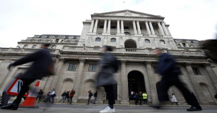 People walk in front of the Bank of England, following an outbreak of the coronavirus, in