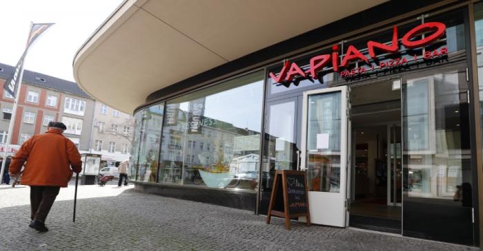 FILE PHOTO:  A man walks past an open Vapiano restaurant during the spread of coronavirus