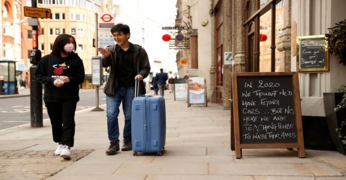 People walk past a pub in Fleet Street