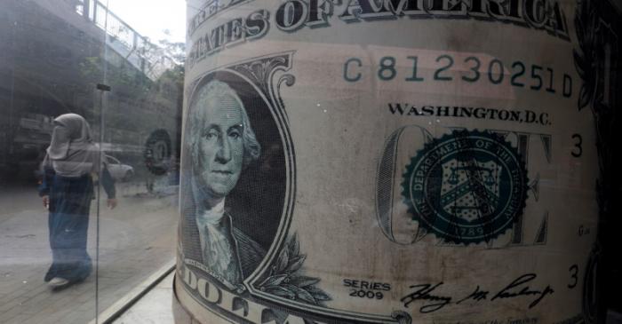 Woman wearing full veil (niqab) walks in front of forex bureau in Cairo