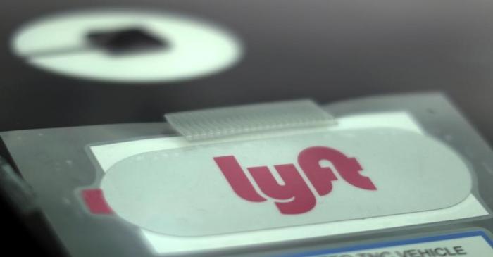 FILE PHOTO: Uber and Lyft stickers are seen on a car windscreen as protesters join an Uber