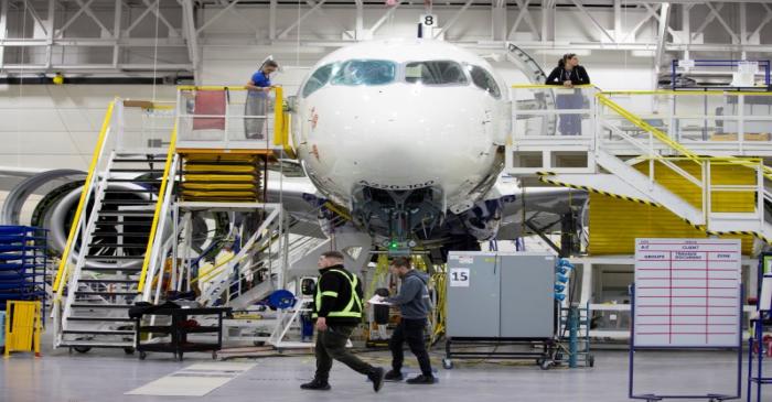 FILE PHOTO: Employees work on an Airbus A220-300 at their facility in Mirabel