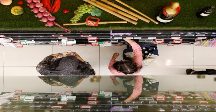 People shop for food at a supermarket in Singapore