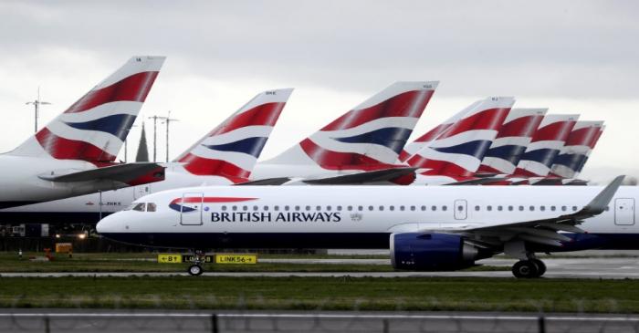 A BA plane taxis past parked aircraft near Terminal 5 at Heathrow Airport