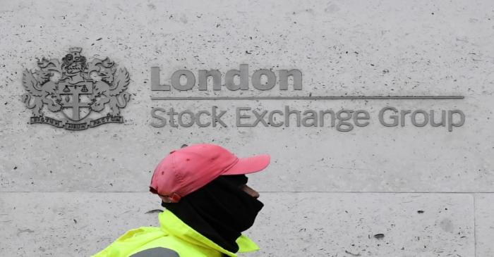 A street cleaning operative walks past the London Stock Exchange Group building in the City of
