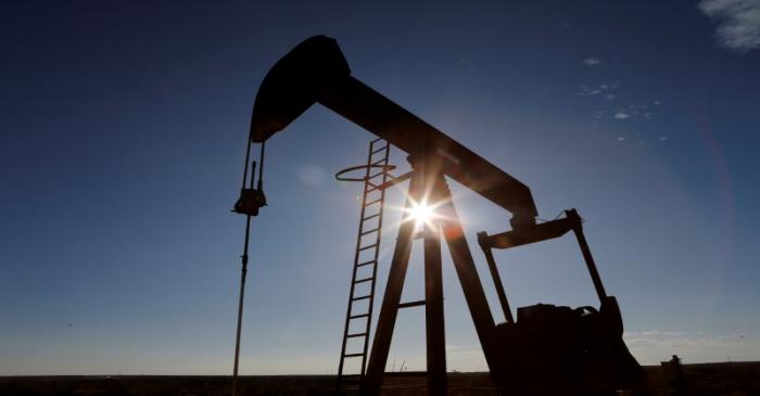 FILE PHOTO: The sun is seen behind a crude oil pump jack in the Permian Basin in Loving County