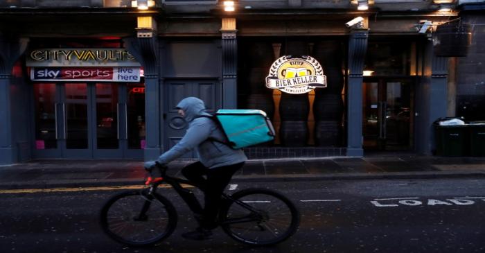 A Deliveroo driver goes past a bar as the spread of the coronavirus disease (COVID-19)