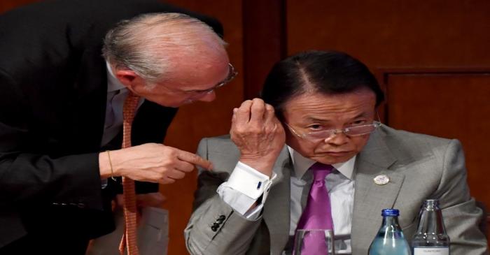 Japanese Finance Minister Taro Aso listens to OECD Secretary-General Angel Gurria during the