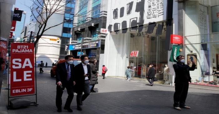 Men wearing masks to prevent contracting coronavirus walk in shopping district in Seoul