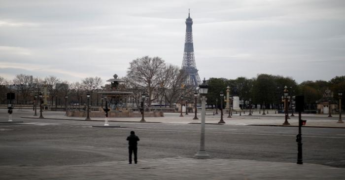 FILE PHOTO: A waiter stands by empty tables outside a restaurant at St Mark's Square, which is