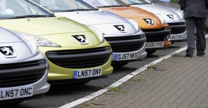 File photo of a man passing cars on a showroom forecourt in west London