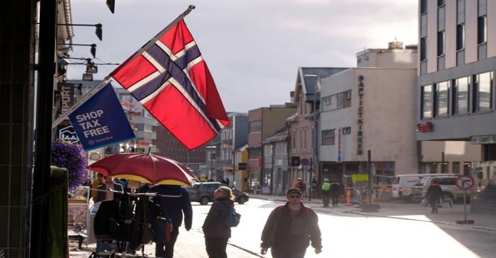 A Norwegian flag flutters over a shop in Tromso