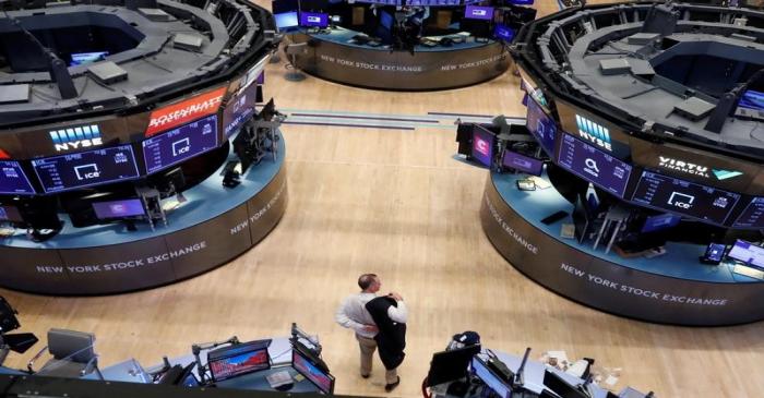 A trader puts on his jacket on the floor of the New York Stock Exchange (NYSE) as the building