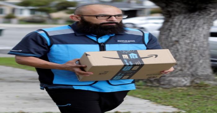 Danny Gonzalez walks with a package when he delivers for Amazon during the outbreak of the