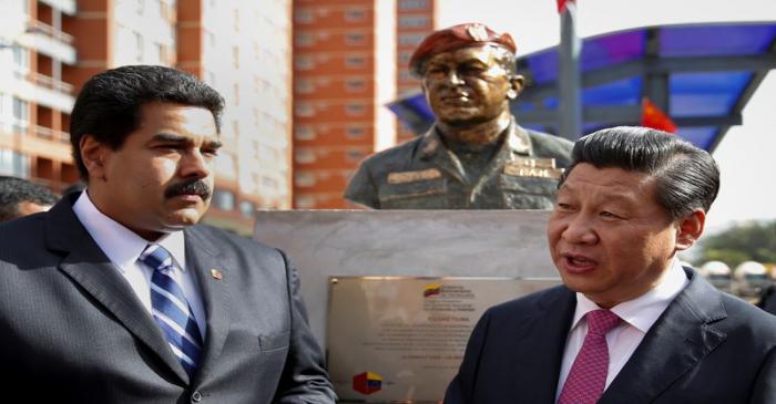 FILE PHOTO: China's President Xi speaks with Venezuela's President Maduro in front of a statue