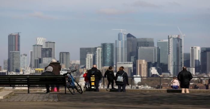 FILE PHOTO: People look out onto the Canary Wharf district as they walk through Greenwich Park