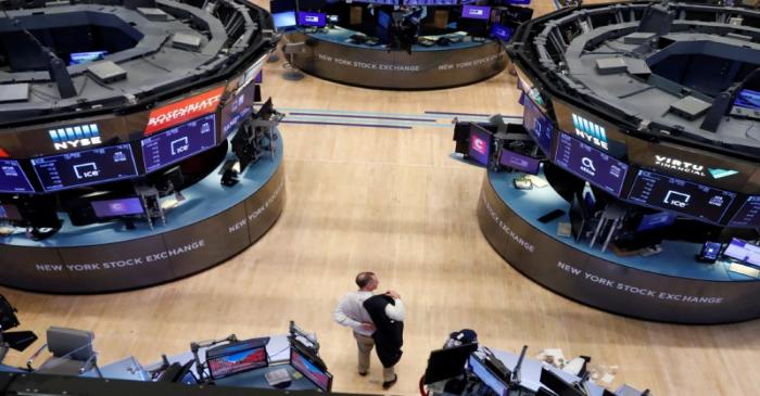 A trader puts on his jacket on the floor of the New York Stock Exchange (NYSE) as the building