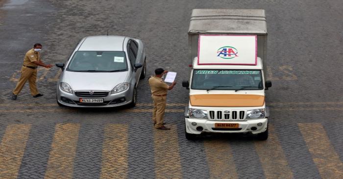 Police officers stop vehicles and check their papers on a highway during 21-day nationwide