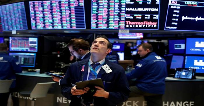 FILE PHOTO: Traders work on the floor of the New York Stock Exchange (NYSE) as the building