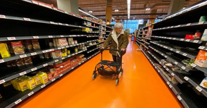 FILE PHOTO: A shopper walks through an aisle empty of pasta, rice, beans and soup at a Loblaws