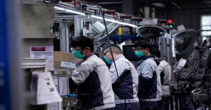FILE PHOTO: Employees wearing face masks work on a car seat assembly line at Yanfeng Adient