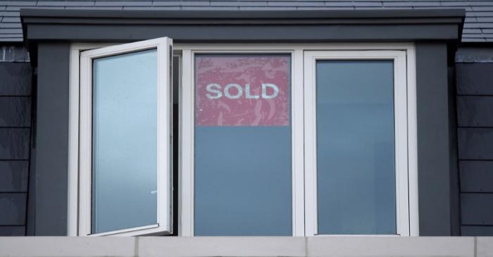 FILE PHOTO: Property sold signs are seen on windows of a group of newly built houses in west