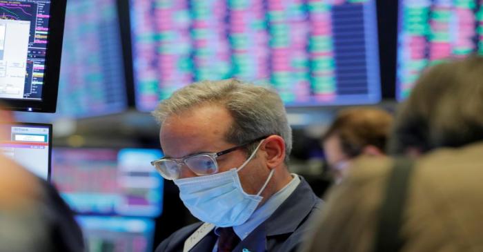 FILE PHOTO: A trader wears a mask as he works on the floor of the New York Stock Exchange