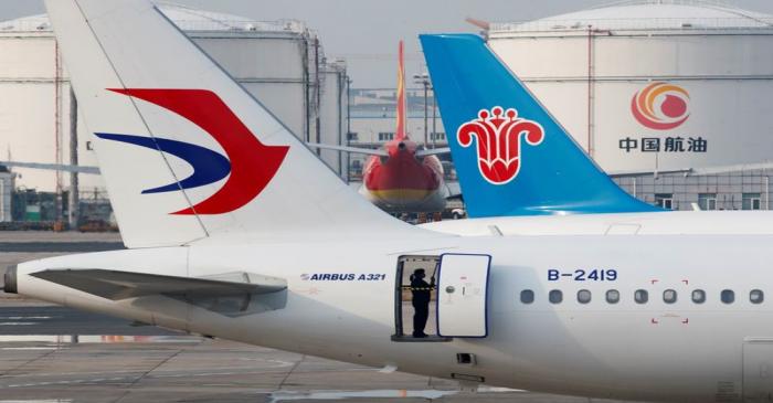 FILE PHOTO: A ground staff worker cleans a parked passenger aircraft at Beijing Capital