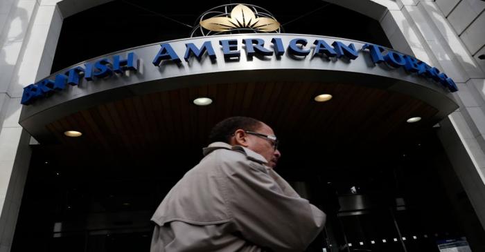 A man walks past the British American Tobacco offices in London