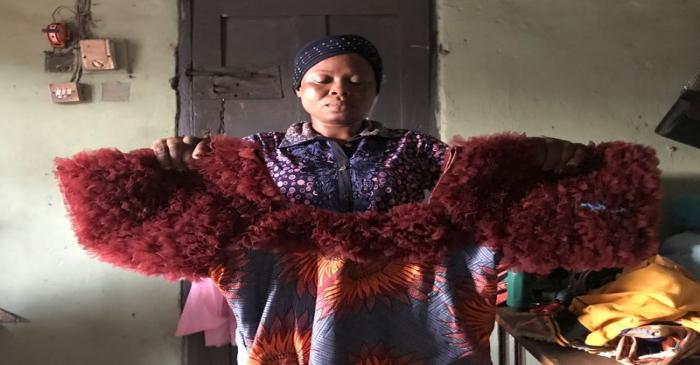 Kemi Adepoju, a dressmaker,  poses with a dress in her shop amid the spread of the coronavirus