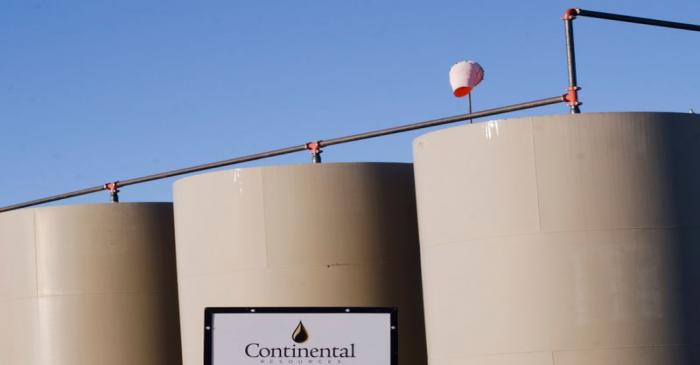 Storage tanks stand on a Continental Resources oil production site near Williston