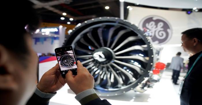 A man takes a picture of a General Electric (GE) engine during the China International Import