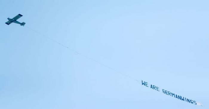 A small airplane pulls a banner while flying over the Lufthansa headquarters in Frankfurt