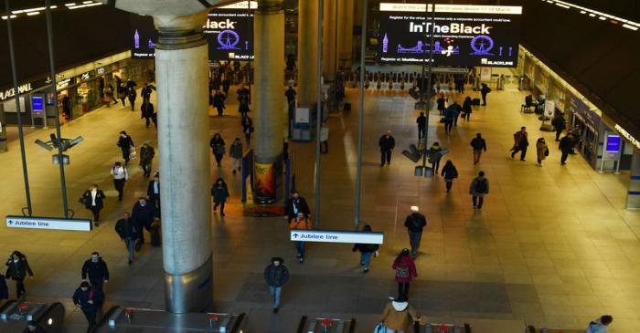 FILE PHOTO: Commuters walk through Canary Wharf in London