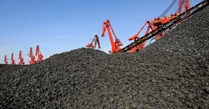 Cranes unload coal from a cargo ship at a port in Lianyungang