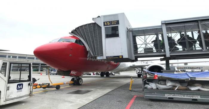 FILE PHOTO: Passengers board a Norwegian Air plane at Oslo Gardermoen airport
