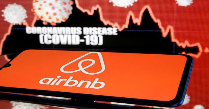 FILE PHOTO: Airbnb logo is seen in front of diplayed coronavirus disease (COVID-19)