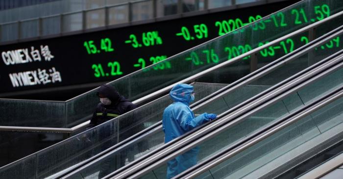 FILE PHOTO: Pedestrian in protective suit rides an escalator near an overpass with an