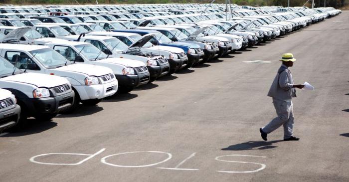 FILE PHOTO: A worker walks near a row of cars at Nissan's manufacturing plant in Rosslyn