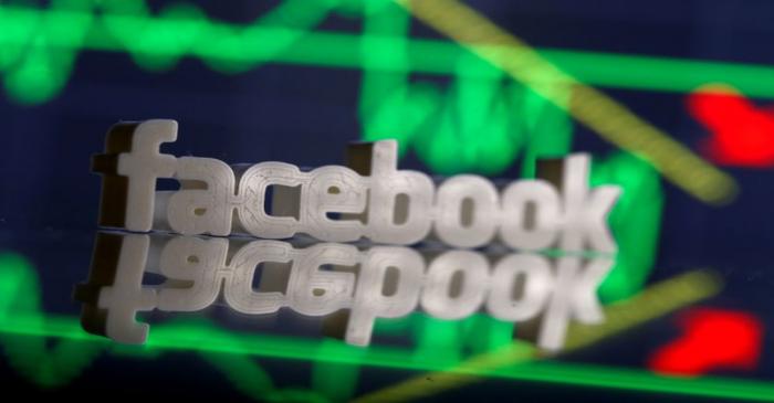 FILE PHOTO:  A 3D-printed Facebook logo is seen in front of displayed stock graph