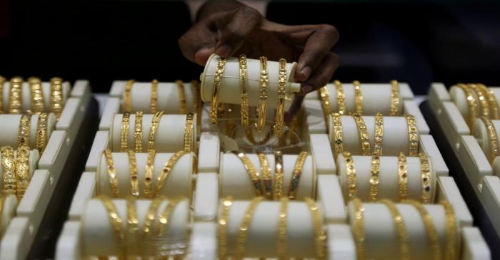 FILE PHOTO: A salesman arranges gold bangles inside a jewellery showroom on the occasion of