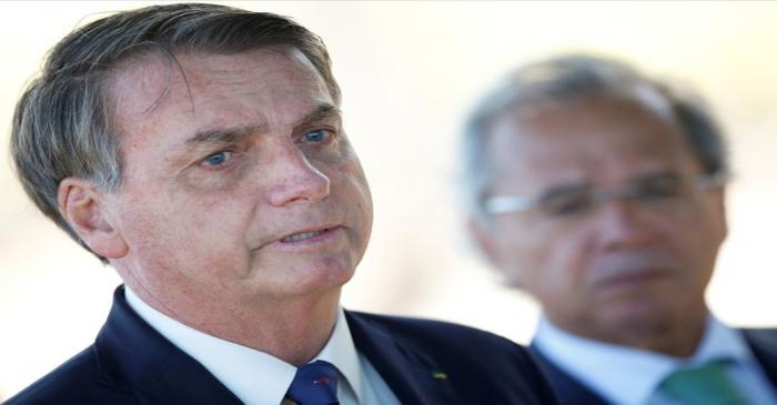 FILE PHOTO: Brazil's President Jair Bolsonaro speaks near Brazil's Economy Minister Paulo