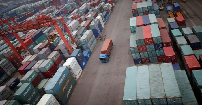 A truck drives between shipping containers at a container terminal at Incheon port in Incheon