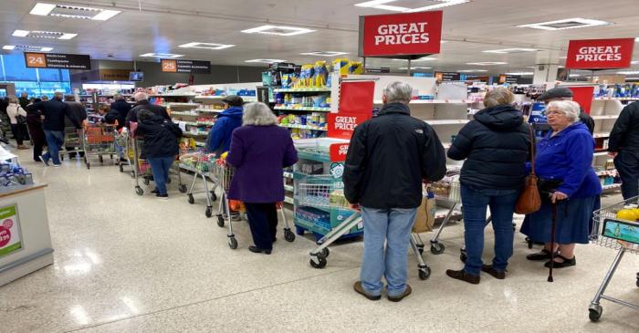 FILE PHOTO: People queue inside a Sainsburys supermarket in Watford